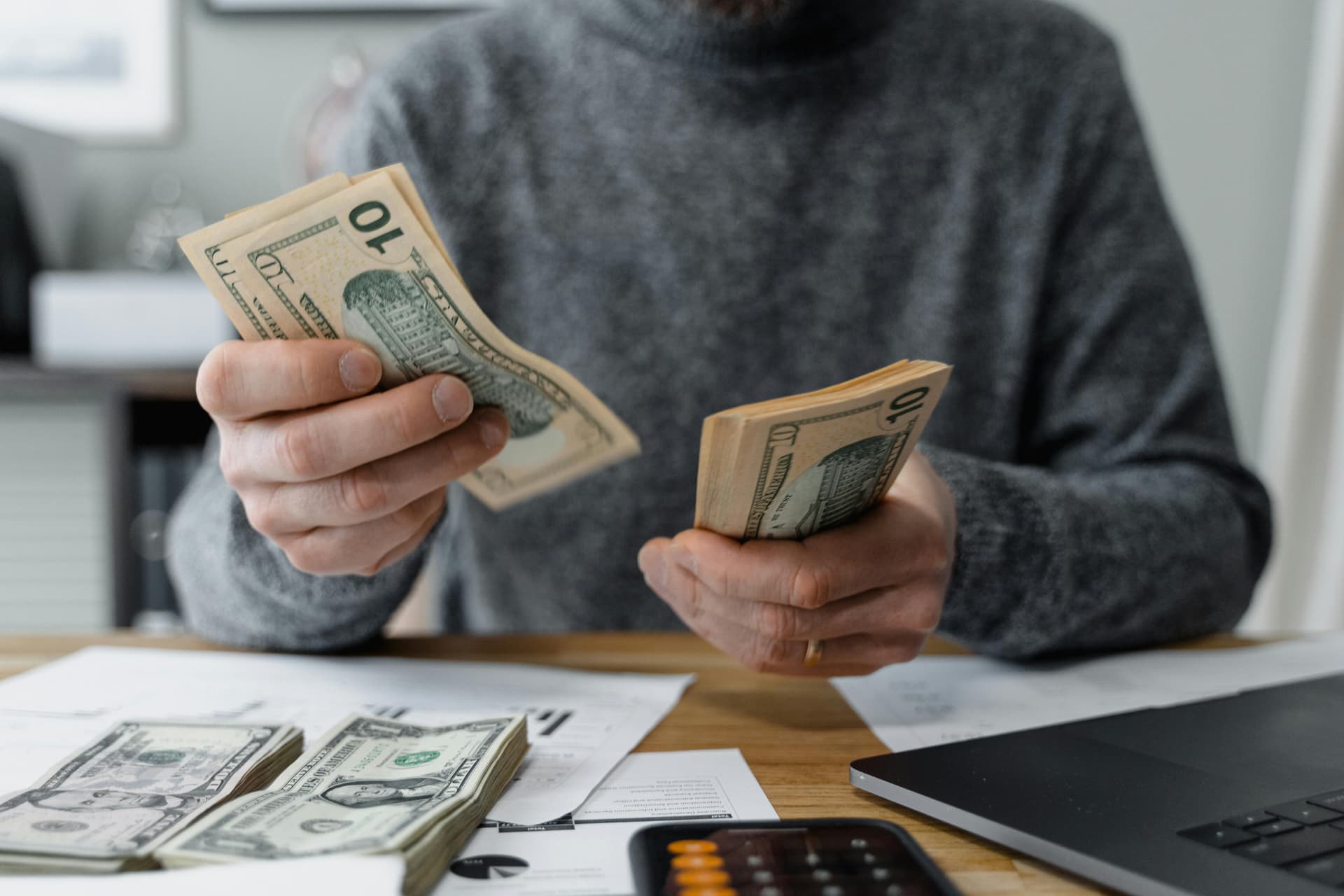 A person counting money, representing the financial benefits of smart tax insights.